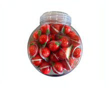 A clear jar filled with red strawberry-shaped gummy candies, showcasing their chewy texture and vibrant color.